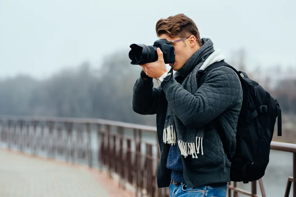 Fotograf cu aparatul în mână, la o ședință foto